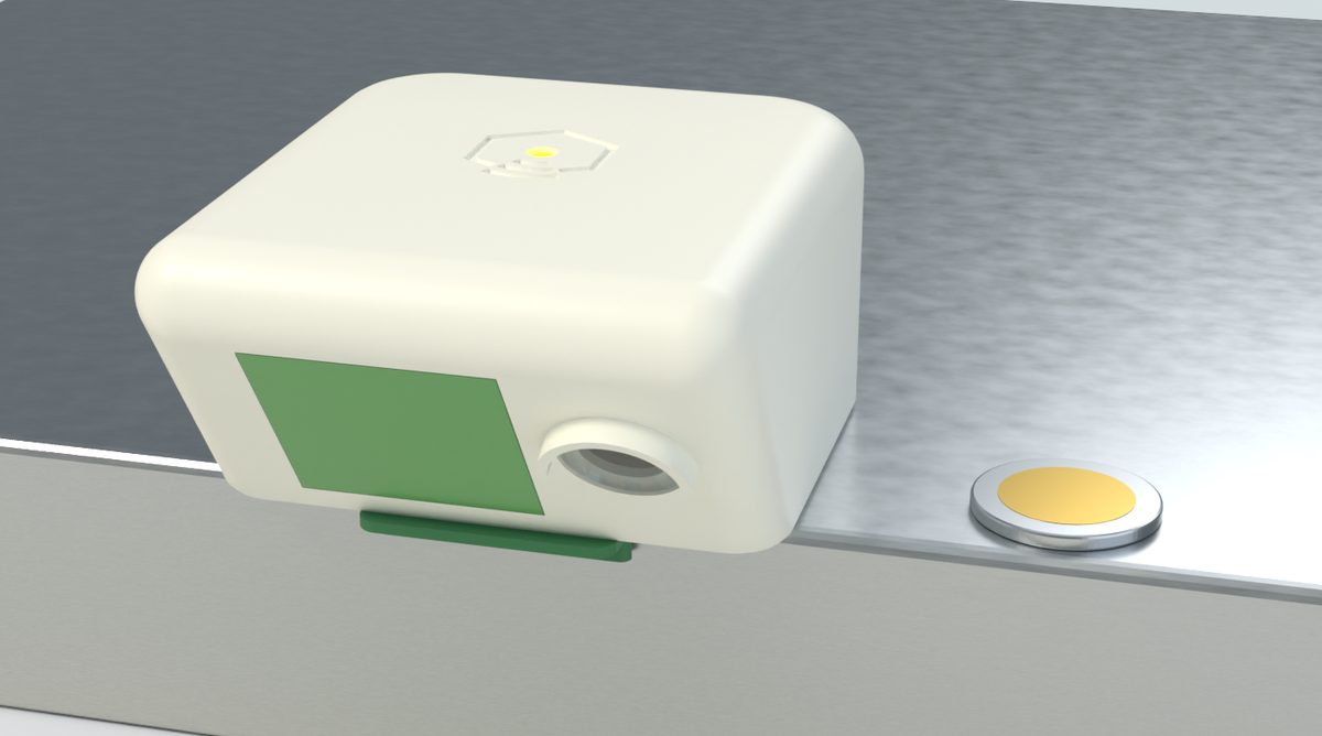 Le module melifly à côté d'une pièce de 2 euros : boîtier couleur lin, fenêtre radar verte et objectif de caméra
